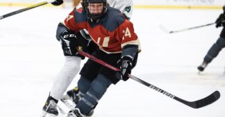 PWHL Montreal player in red and PWHL Boston player in white compete for the puck during a recent preseason matchup.